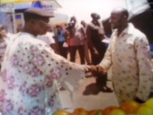 Sir Ono Edeh, Resident Director, Coastline Microfinance Bank in a handshake with one of the beneficiaries, Ojiwete Emmanuel at the event. 