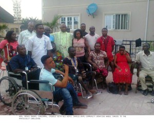 Sapele-Okpe Council Chairman in a group photograph with the physically challenged in their new wheelchairs.